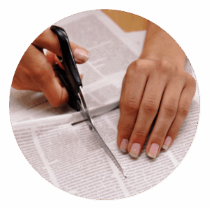 what is news clipping? someone cutting a newspaper article out of a newspaper